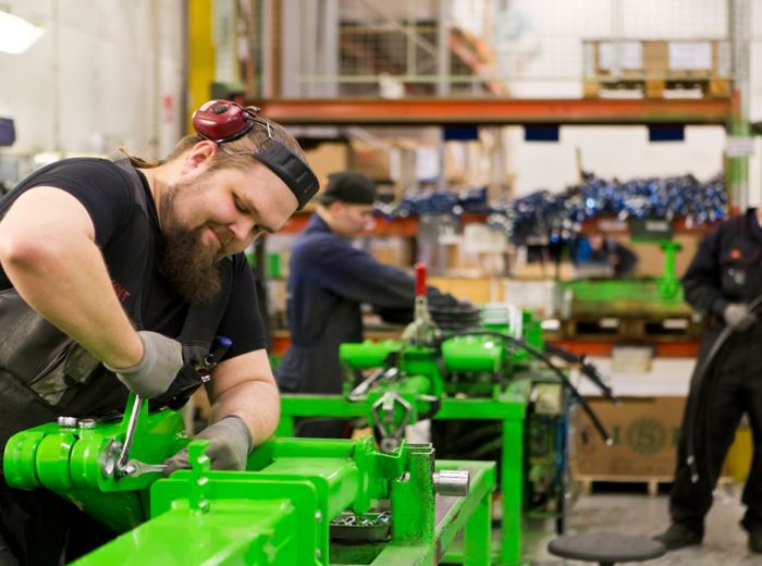 Ein Fabrikmitarbeiter arbeitet an einer Maschine, um die Fertigung von Produkten zu optimieren