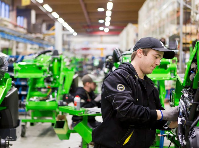 Ein Mitarbeiter in einem Lager arbeitet an einer grünen Maschine in einer Fabrik