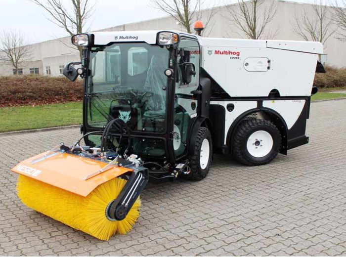 Ein großer gelber Pinsel liegt auf dem Boden neben einer Multihog Kompaktserie CL Maschine