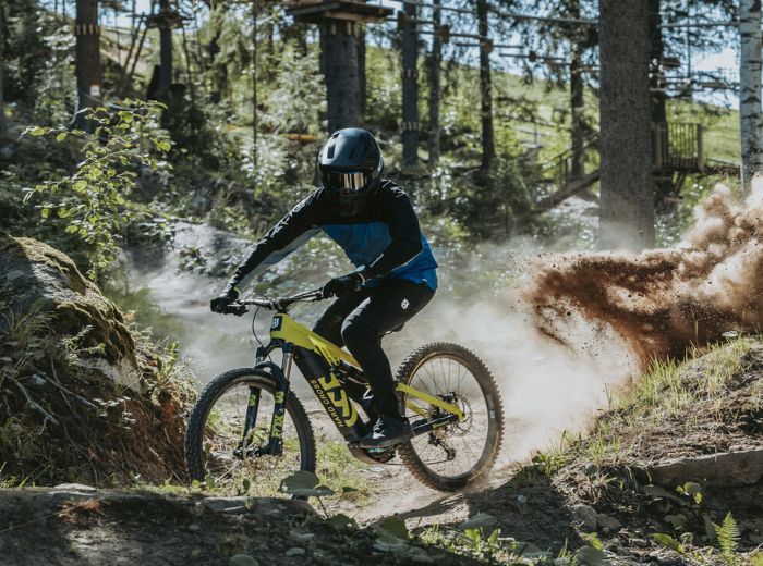 Mountainbiker auf einem Waldweg in Pierer, umgeben von Bäumen und Natur